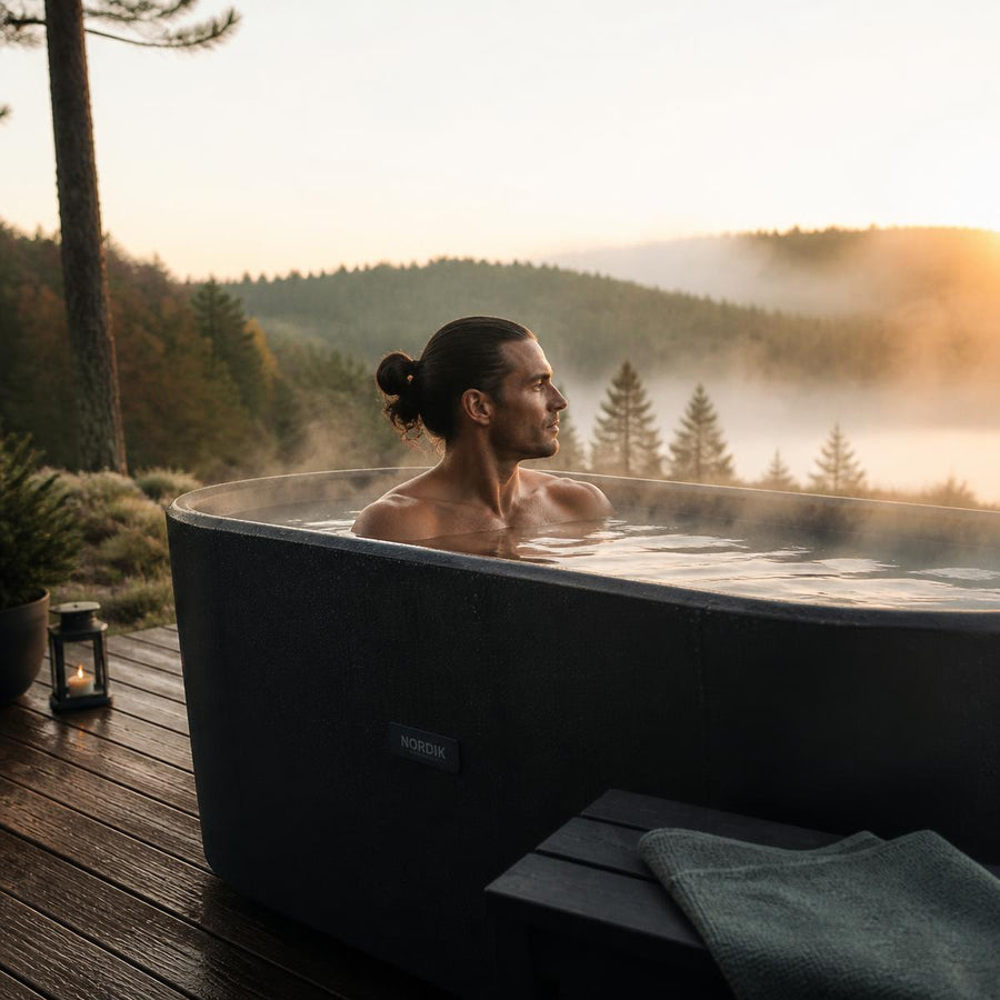 Person relaxing in a Glacian tub outdoors at sunrise